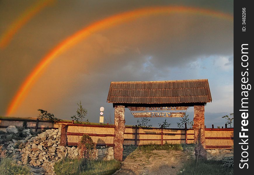 Rainbow over an entrance to a village in Romania.