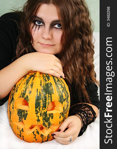 Adorned girl to Halloween c by pumpkin in the hands. Adorned girl to Halloween c by pumpkin in the hands