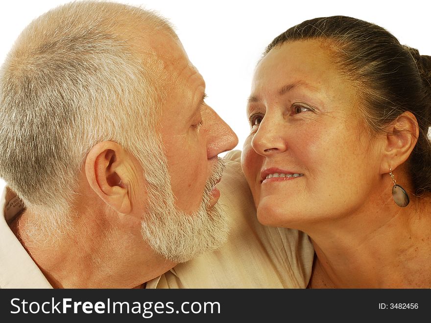 Attractive older couple looking at each other lovingly; isolated on white. Attractive older couple looking at each other lovingly; isolated on white