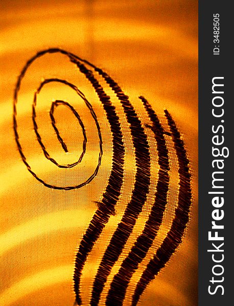 A closeup of a detail on a piece of fabric in front of sun lighting. A closeup of a detail on a piece of fabric in front of sun lighting.
