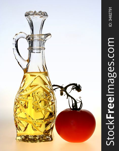 Oil pitcher with a tomato on a blue and yellow background. Oil pitcher with a tomato on a blue and yellow background.