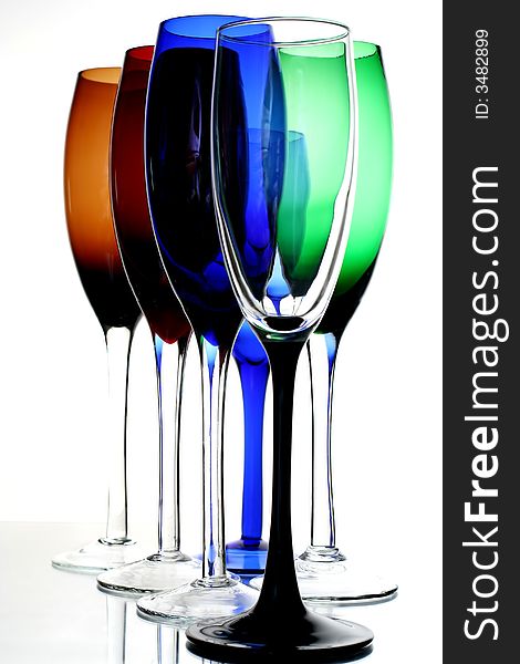 Colored champagne glasses on white background.