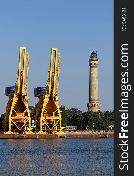 Lighthouse and cranes by the sea. Lighthouse and cranes by the sea
