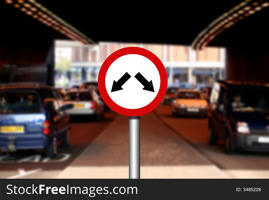 Road traffic sign with two arrows and blurred traffic in background