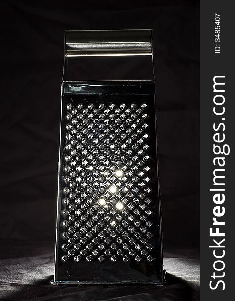 Shining parmesan grater, isolated on black. Shining parmesan grater, isolated on black