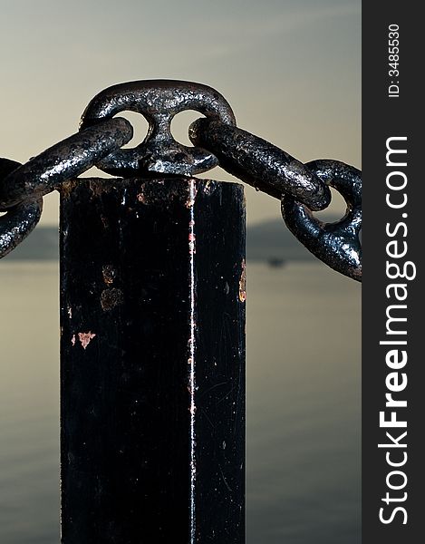 A solid black chain with a placid lake in background. A solid black chain with a placid lake in background