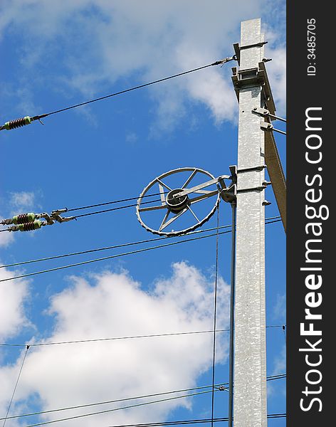 Track electricity line tensioner with blue sky and white clouds