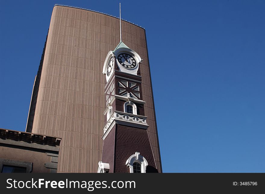 A church tower with a modern building behind