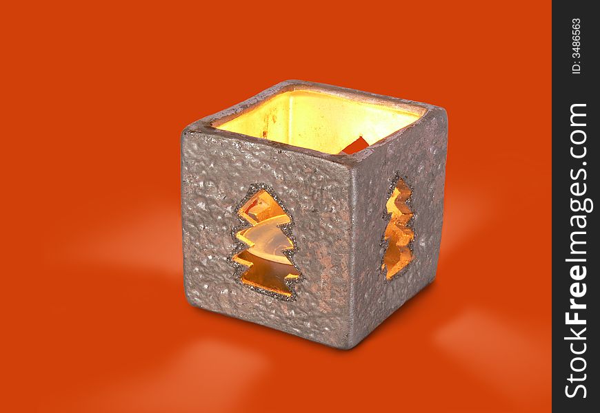 There is xmascandle in silver box-candlestick on red background