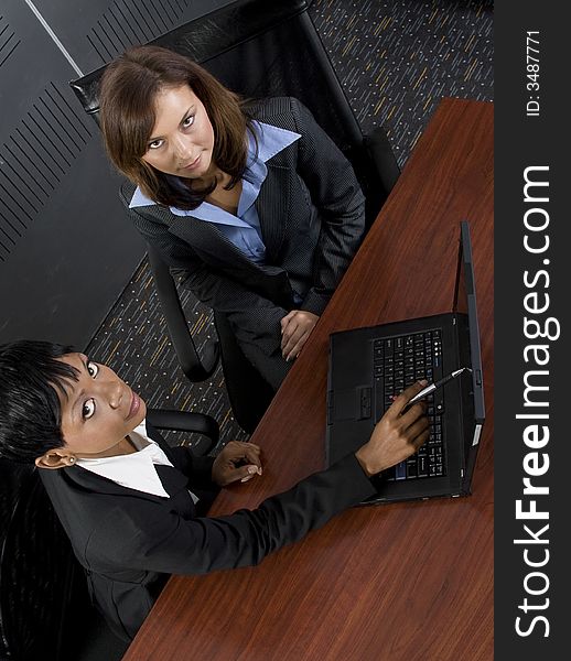 Multi-racial business team working within an office with a laptop computer. Multi-racial business team working within an office with a laptop computer