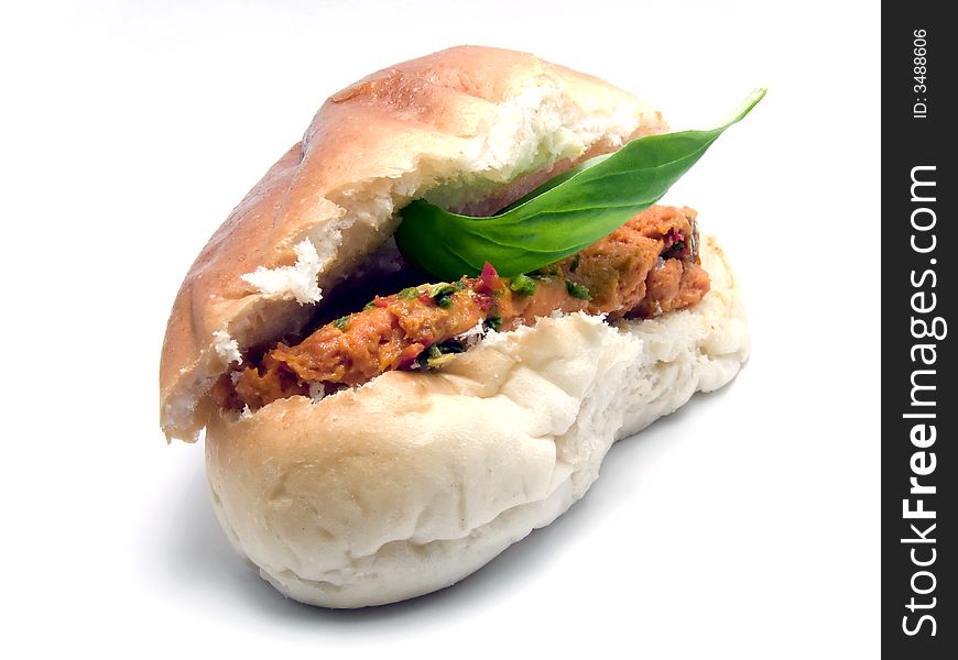 A roll with minced meat and a leaf of basil. A roll with minced meat and a leaf of basil