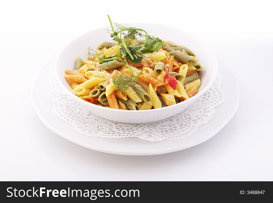 Italian colorful penne pasta in white bowl over a white background. Italian colorful penne pasta in white bowl over a white background