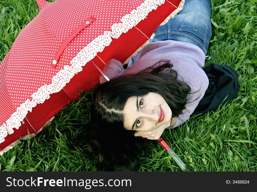 A girl looking up holding a red umbrella. A girl looking up holding a red umbrella