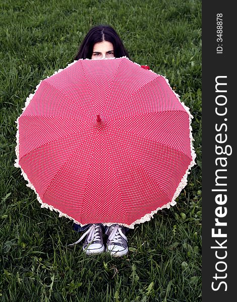 A girl hiding behind a red umbrella. A girl hiding behind a red umbrella
