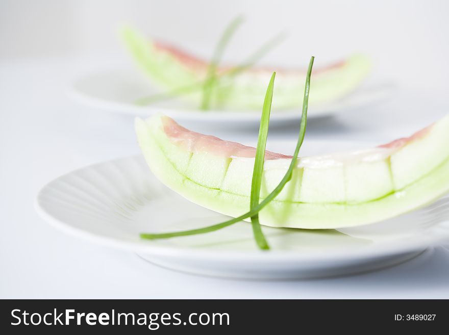 Honey due melons on white plate