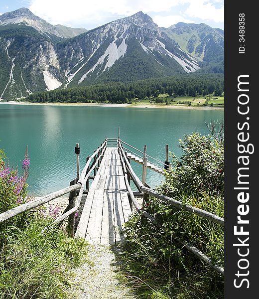 Wooden small jetty in mountains. Sunny summer day. Wooden small jetty in mountains. Sunny summer day.