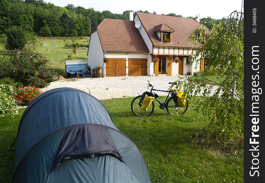 Big green tent in garden. In background bike and house. Big green tent in garden. In background bike and house