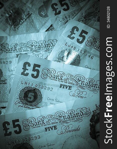 Tinted image of British five pound banknotes. Tinted image of British five pound banknotes