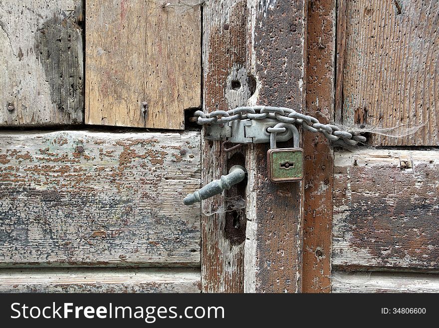 Old wooden door with padlock in the middle