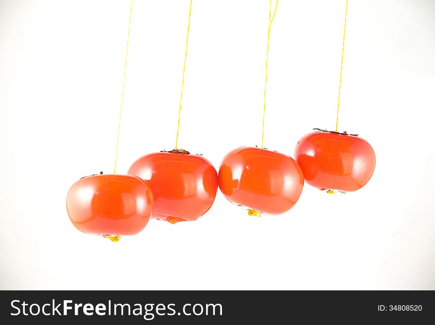 Hanging red tomatos on white. Hanging red tomatos on white