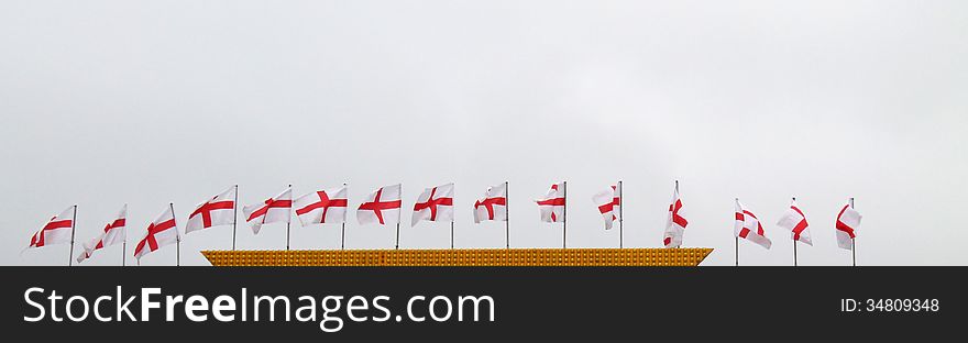 A Line of English Flags on a Building Rooftop. A Line of English Flags on a Building Rooftop.