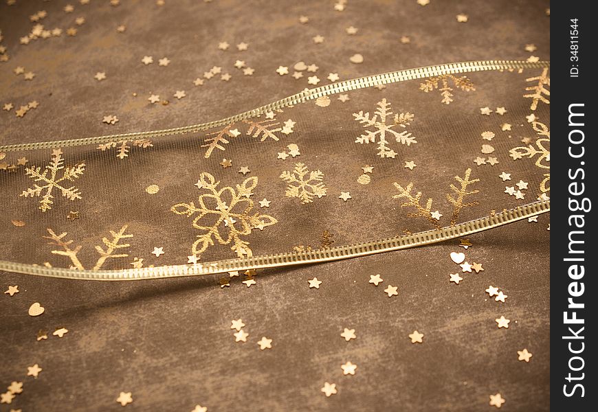 Golden snowflake ribbon with golden stars on golden background. Golden snowflake ribbon with golden stars on golden background