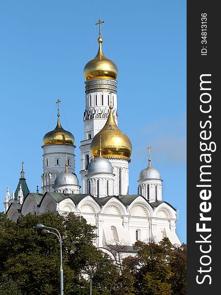 Lovely view from Moscow Ivan the Great bell tower and the church against the blue sky and trees