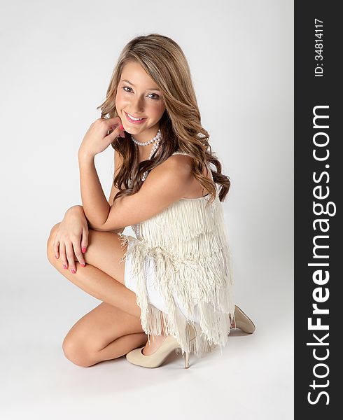 An image of a cute, smiley teen in a fringed flapper dress. An image of a cute, smiley teen in a fringed flapper dress