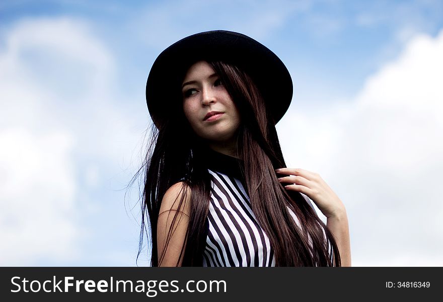 Girl in black hat and blue sky. Girl in black hat and blue sky