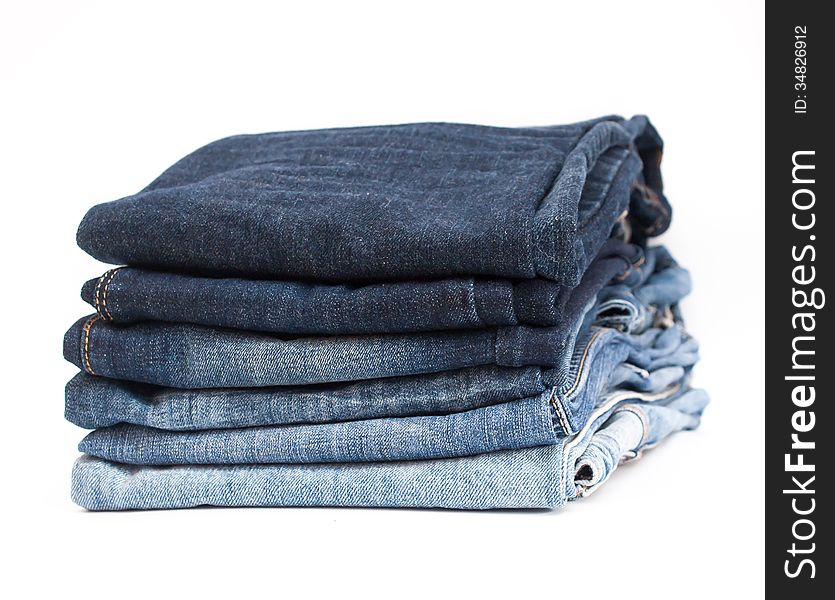 Photo of stack of jeans in gradient color order on white background. Photo of stack of jeans in gradient color order on white background