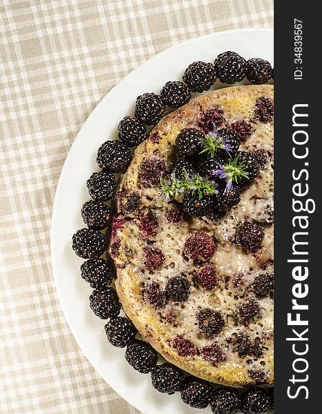 Blackberry Clafoutis on plate with fresh berries. From series Summer desserts