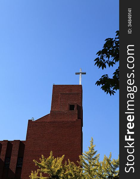 The cross of the church look solemn under the blue sky. The cross of the church look solemn under the blue sky