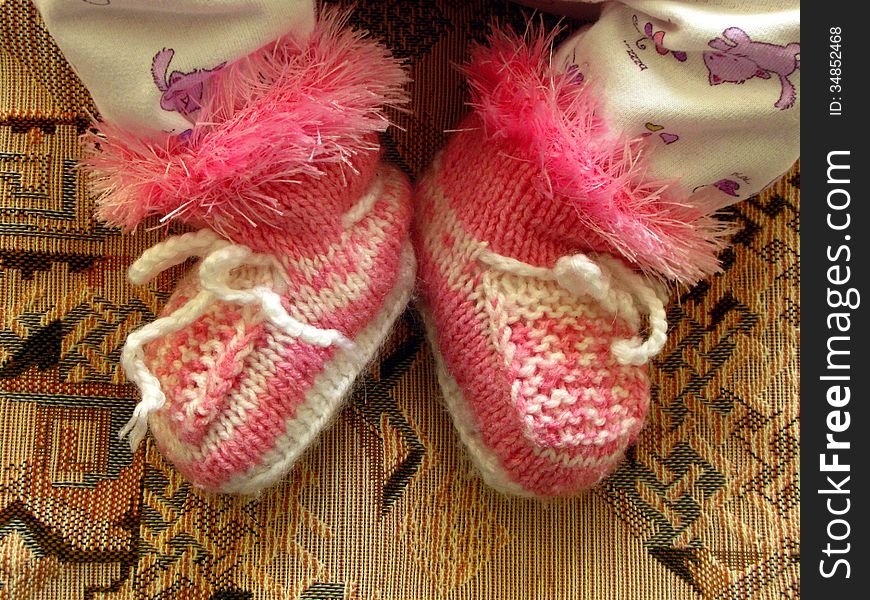 Baby bootees on newborn child feet