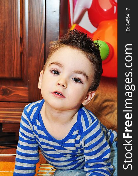 Portrait of a happy baby boy sitting on the floor. Portrait of a happy baby boy sitting on the floor.