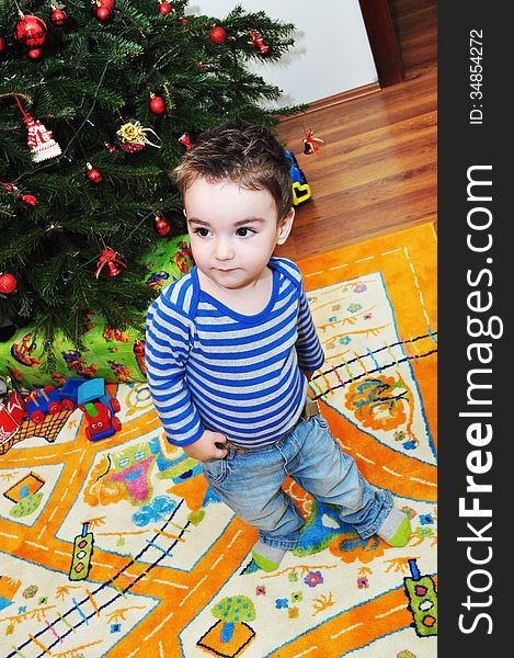 A portrait of a happy baby boy near Christmas tree. A portrait of a happy baby boy near Christmas tree.