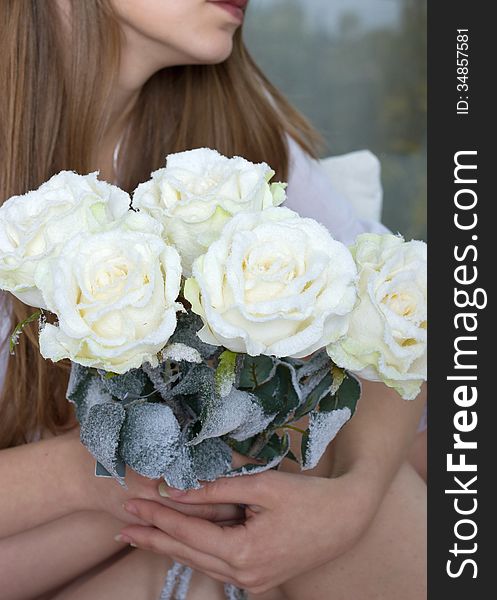 Gothic style. Woman with a rose in hands in snow-covered. Gothic style. Woman with a rose in hands in snow-covered