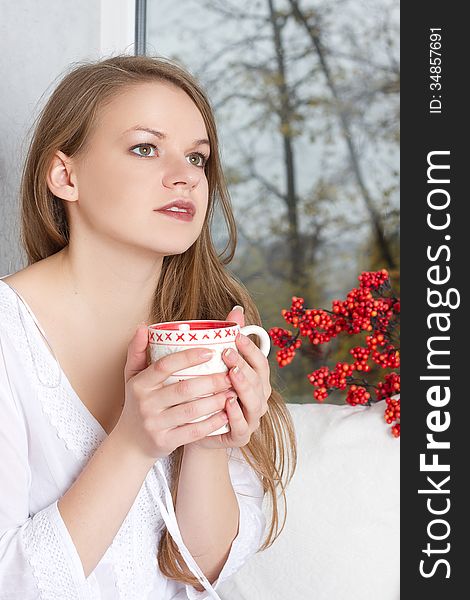 Girl Holding Cup And Looking Through Window