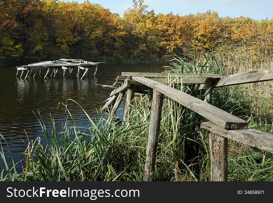 Forest pond. The broken pier. Autumn forest