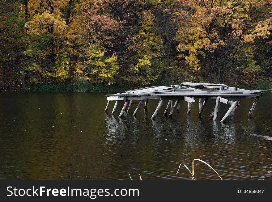 Forest pond. The broken pier. Autumn forest