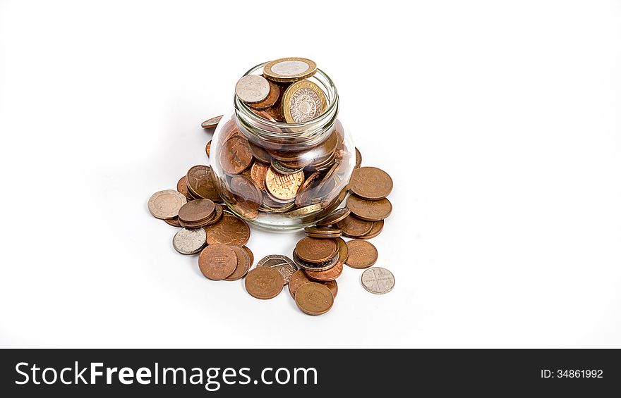 Coins overflowing from money jar isolated on wite background