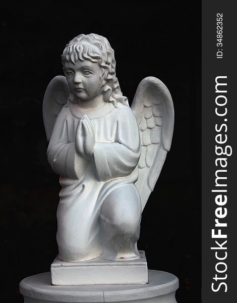 Figure of a praying angel in the cemetery