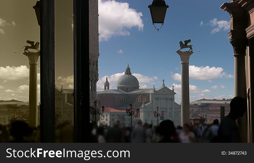 Italy. Venice. San Marco square. View from the gallery of Procuratie Vecchie on the St.Mark's column and San Giorgio Maggiore. Clouds quickly run through the blue sky