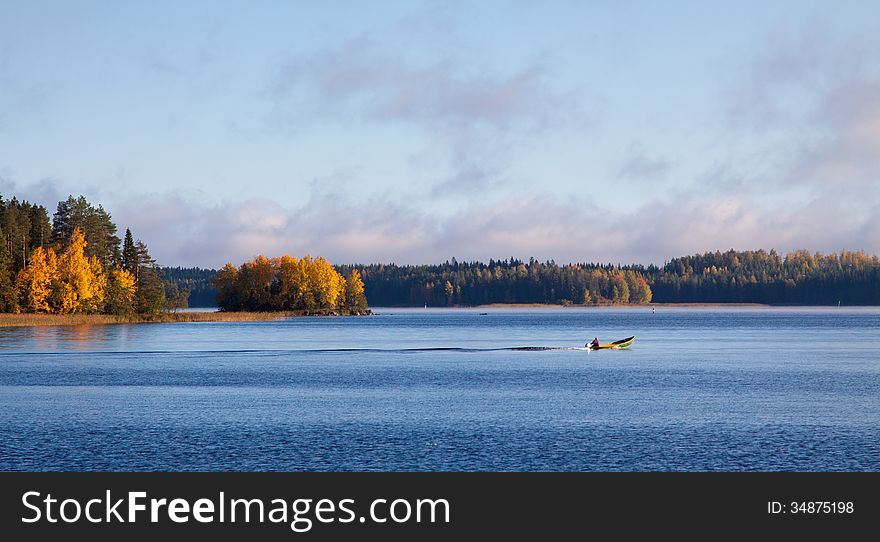 Fisherman on a boat in a lake in autumn