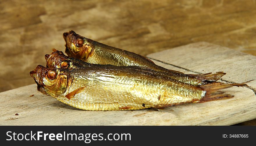 Smoked fish on brown background