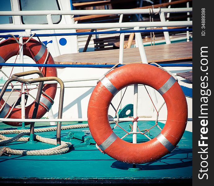 Ship railing and life buoy. View from the deck of a boat. Sea travel background with lifebuoys.