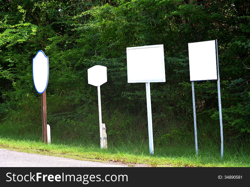 Blank signs at the side of a road right next to each other. Blank signs at the side of a road right next to each other