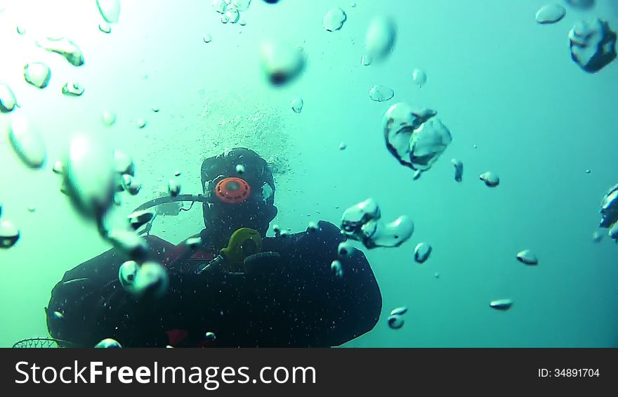 Underwater video. Unrecognized diver rises to the surface. Many air bubbles. Underwater video. Unrecognized diver rises to the surface. Many air bubbles