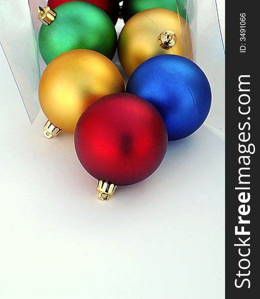 Plastic box with colorful Christmas ornaments spilling out. Plastic box with colorful Christmas ornaments spilling out.