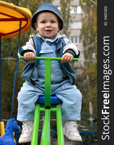 Excited little boy on a swing in a playgroung. Excited little boy on a swing in a playgroung