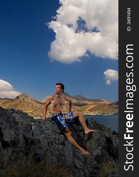 Handsome man relaxing in mountains, beautiful landscape view behind him